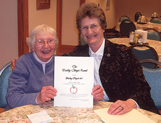 Sister Judith Best (right) shares a Sturdy Roots moment with Sister Dorothy Olinger as she displays her award acknowledging her role as an outsanding educator.
