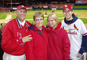 The Sohm family is enjoying a Cardinal baseball game. From left to right: Frank, Benita, Anna and Joe.