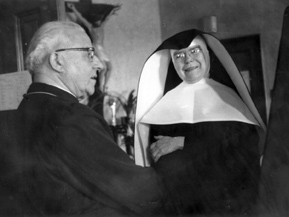 Sister Mary Basil Roeser, SSND shares a humorous moment with Archbishop William E. Cousins as they discuss business together.